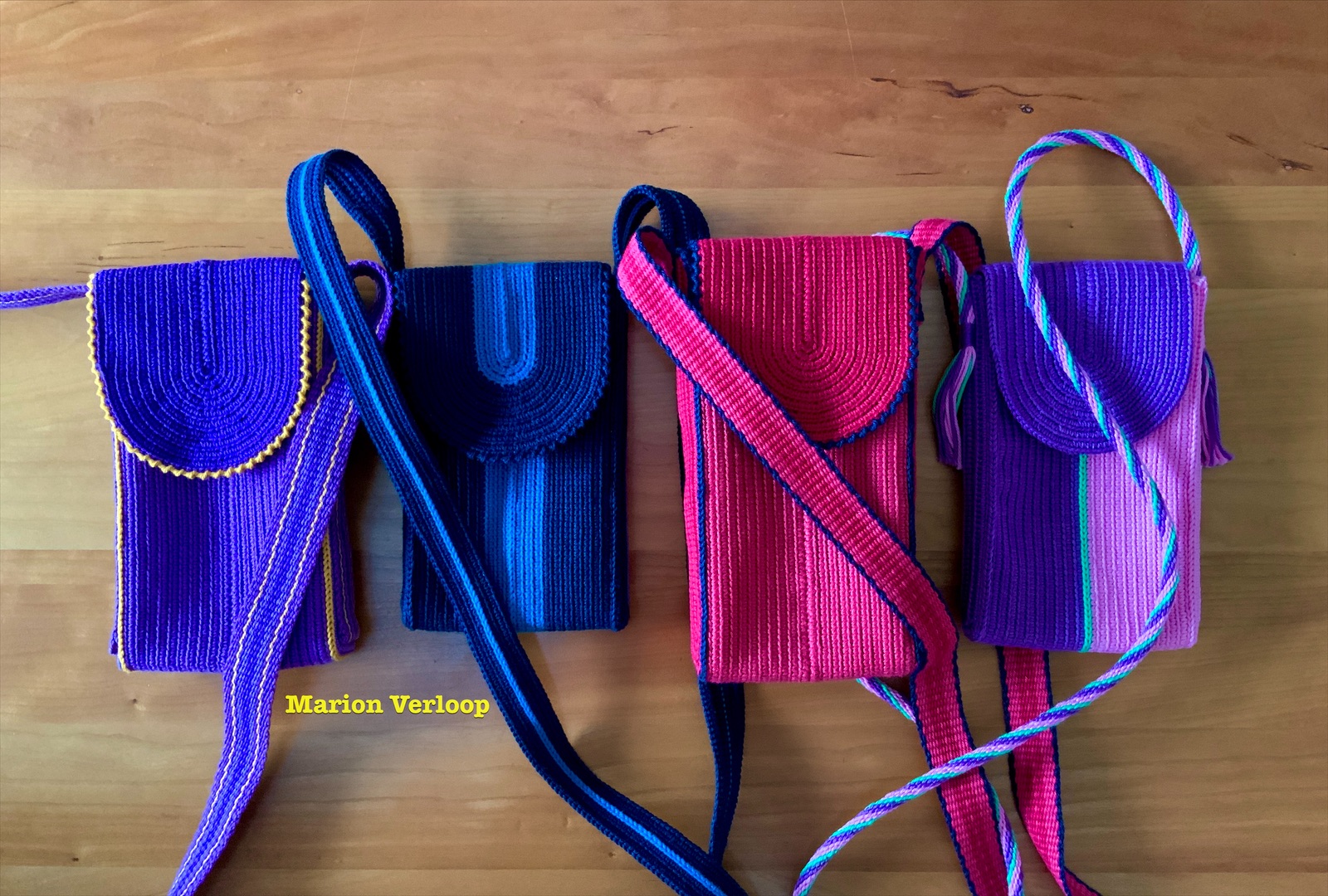 Wayuu-inspired tapestry crochet phone pouches in pink, purple, blue, and mixed colors by Marion Verloop