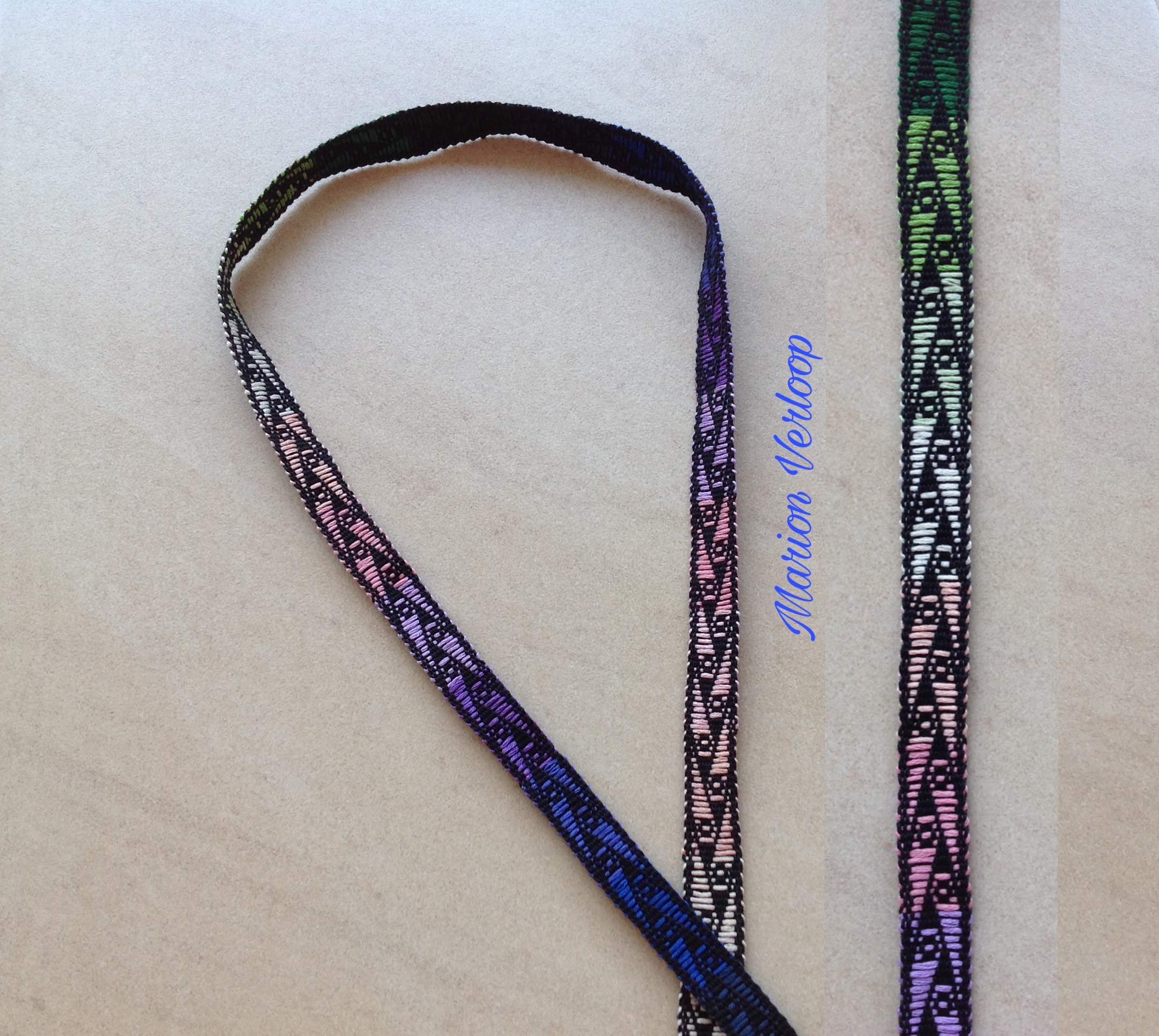 Handwoven band made with the supplementary weft technique, featuring rainbow colors and shades of blue.